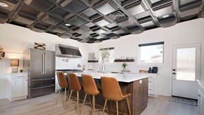 A modern kitchen with a central island, stainless steel appliances, and a unique ceiling design. - 3BR Sleep 6 PALO DURO CANYON Cabin + WTAMU Trails (Canyon)