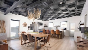 A modern kitchen with a wooden dining table, chairs, and a hanging light fixture. - 3BR Sleep 6 PALO DURO CANYON Cabin + WTAMU Trails (Canyon)