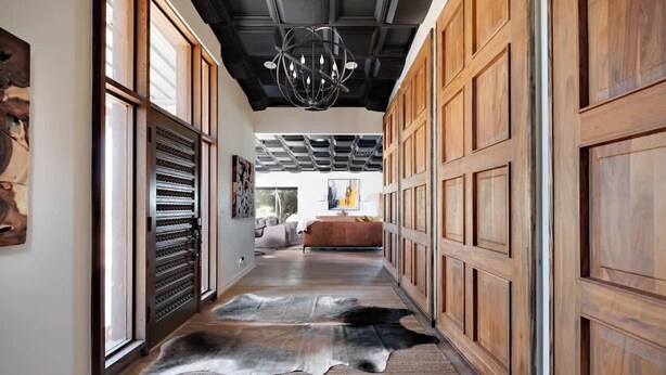 A hallway with wooden paneling, a chandelier, and a fur rug. - 3BR Sleep 6 PALO DURO CANYON Cabin + WTAMU Trails (Canyon)