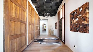 Un pasillo con paneles de madera, alfombra de piel y una obra de arte de madera colgada en la pared.