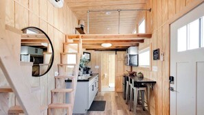 Una cocina compacta con paredes de madera, una isla central y un pequeño comedor.