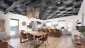 Una cocina moderna con una mesa de comedor de madera, sillas y una lámpara colgante.
