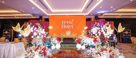 Une scène avec une décoration représentant l’hôtel « Levo! », entourée d’arrangements floraux et agrémentée d’un fauteuil doré.