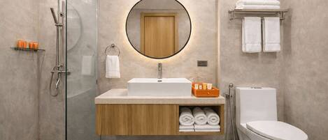 Ein modernes Badezimmer mit Duschkabine aus Glas, einem Holz-Waschtisch, einem weißen Waschbecken und einer Toilette.