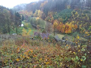 A rural landscape with a valley, trees in autumn colors, and a small house. - Peace and relaxation in Saxon Switzerland (Sebnitz)