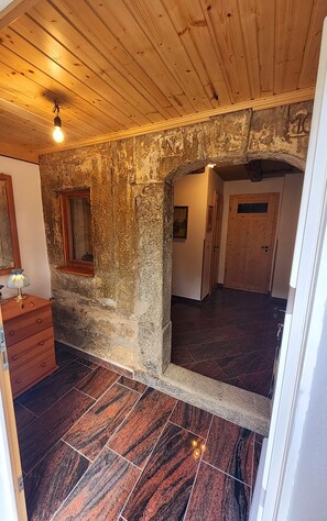 A room with a stone wall, wooden ceiling, and a tiled floor. - Peace and Relaxation in Saxon Switzerland (Sebnitz)
