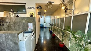 A hotel reception area with a marble counter, a reception desk, a sign indicating CCTV surveillance, and a sign for the lift lobby. - VIKRANT RESIDENCY 59 (Gurugram)