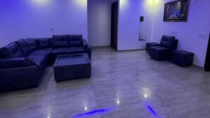 A modern living room with a sectional sofa, a coffee table, and a small side table. - VIKRANT RESIDENCY 59 (Gurugram)