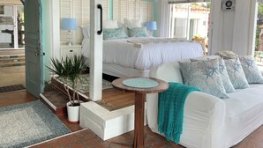 A bedroom with a bed, bedside tables, a nightstand, a potted plant, a small round table, and a sofa. - 100' of Ocean Frontage at Moonlight Beach (Encinitas)