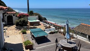 A patio with a ping pong table, seating, and a hot tub overlooking the ocean. - 100' of Ocean Frontage at Moonlight Beach (Encinitas)