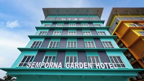 Um hotel com vários andares e uma placa bem visível com a inscrição "SEMPORA GARDEN HOTEL".