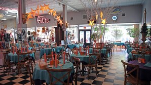 A restaurant with tables set for dining, a neon 'Gifts' sign, and a checkered floor. - Charming Dade City Home with Fire Pit & Garden (Dade City)