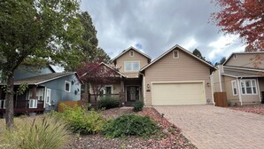 A residential area with houses, a driveway, and a landscaped garden with rocks and plants. - Amythist (Flagstaff)