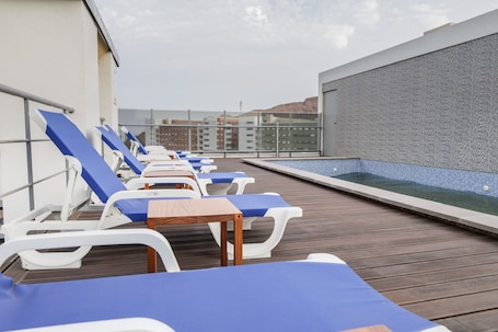 Una piscina al aire libre, sombrillas, sillones reclinables de piscina. Happy Day Hotel