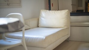 A small, white, single-bed room with a simple, clean design.