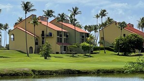 A large building with a red roof, surrounded by palm trees and a body of water. - Carey Beach Villa at Palmas del Mar (Palmas del Mar)