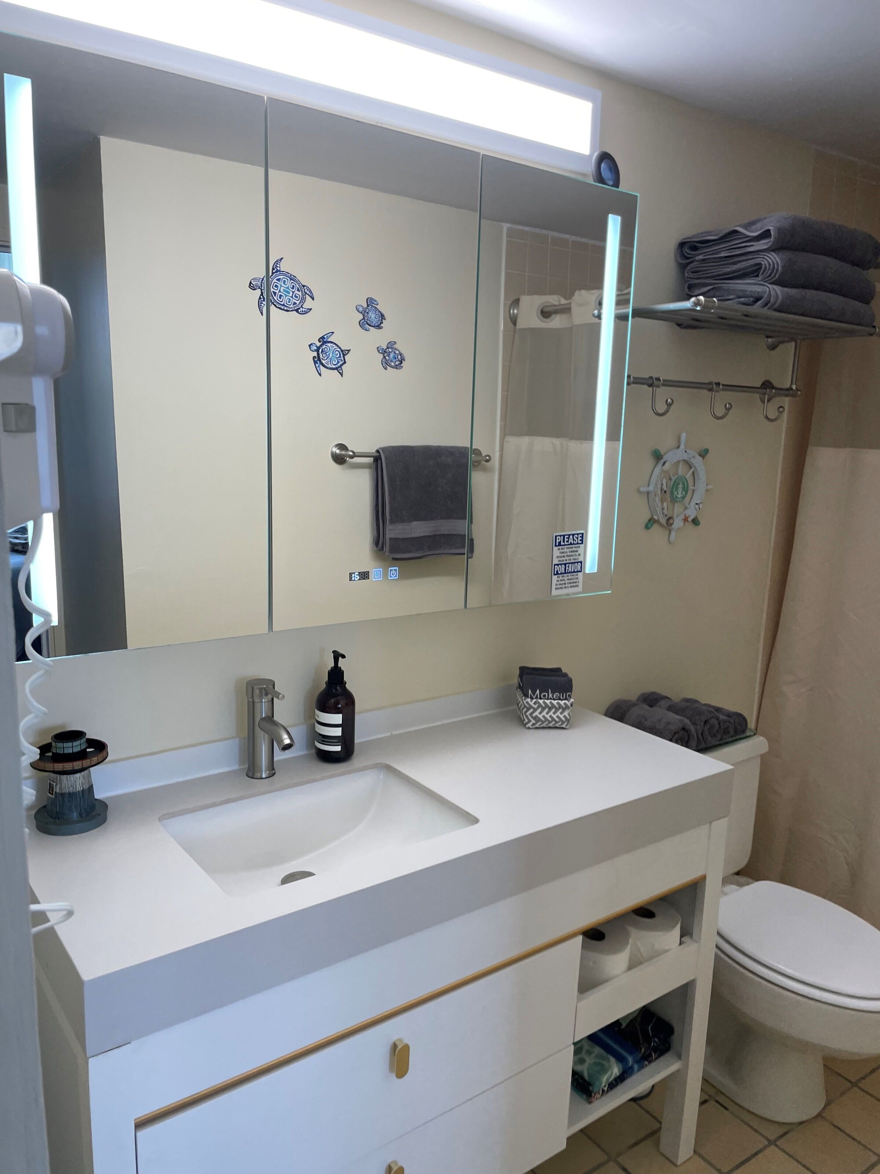 A bathroom with a white sink, a mirror, a towel rack, and a toilet.