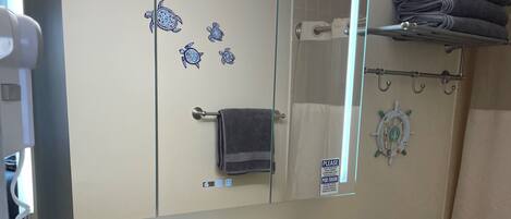 A bathroom with a white sink, a mirror, a towel rack, and a toilet.