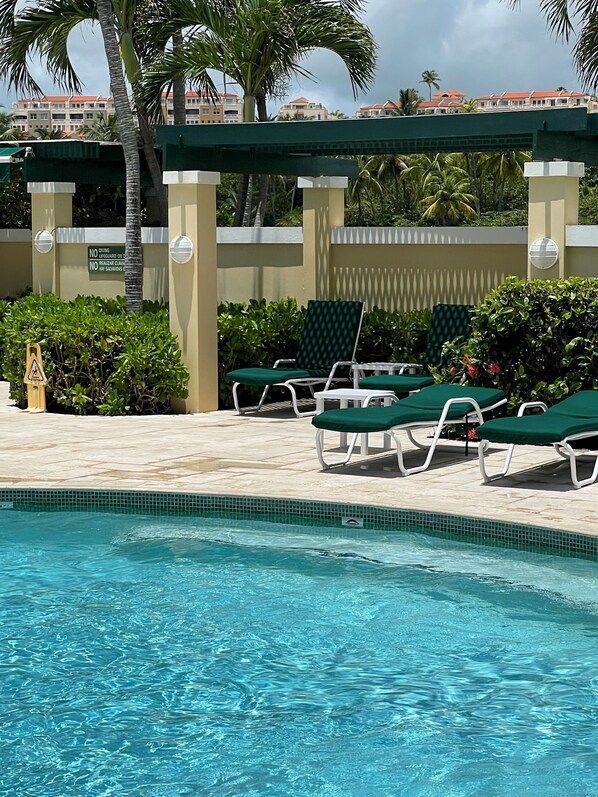 Un espace piscine avec des chaises longues et un panneau indiquant qu’il est interdit de plonger.