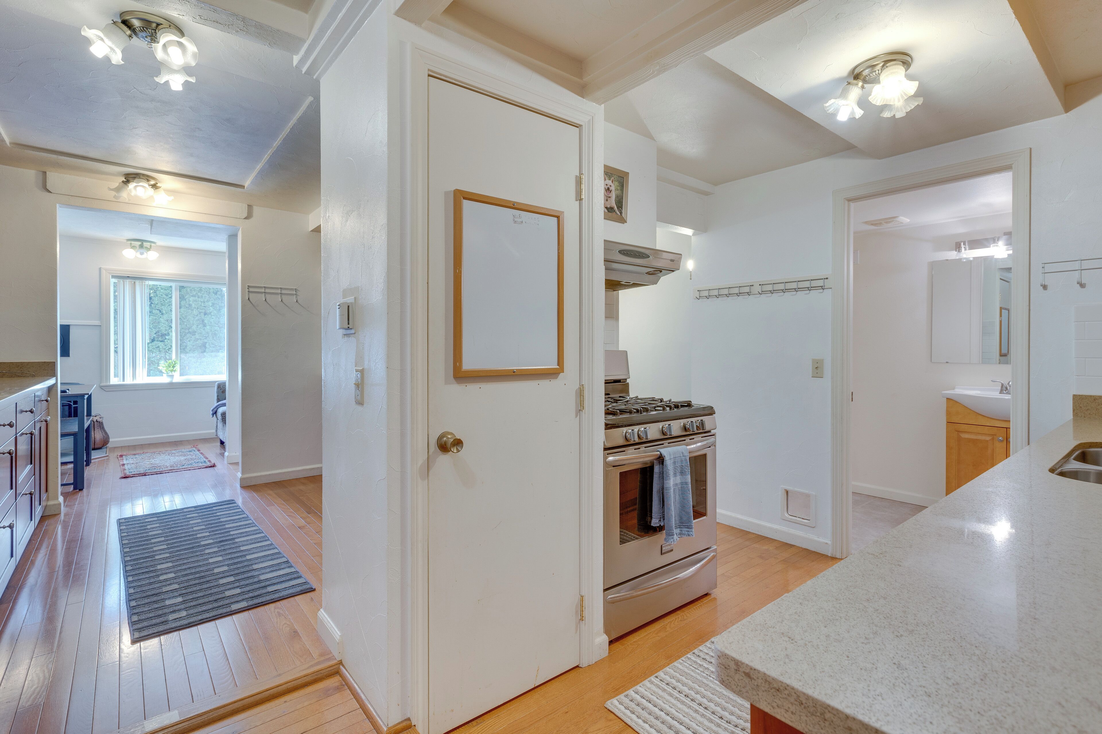 A kitchen with a stove, oven, and a white door.
