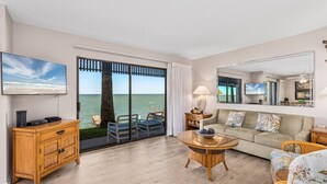 Amplio salón con un gran ventanal corredera que da a un balcón con vistas al mar.