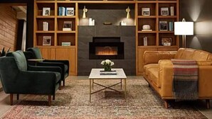 A living room with a fireplace, two sofas, a coffee table, and a bookshelf. - Westwood Living - Gorgeous Modern One Bedroom Available For Rent, Close to UCLA (Los Angeles)