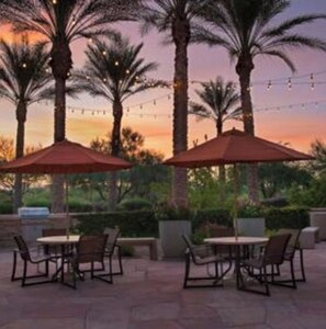 Enjoy al fresco dining and socializing in a serene setting surrounded by palm trees.