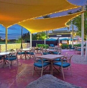 Enjoy communal dining under a spacious canopy in a serene outdoor setting.