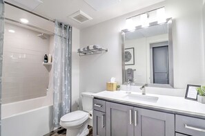 Ein modernes Badezimmer mit Badewanne, Toilette und Waschtisch mit Spiegel.