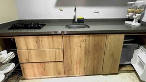 Una cucina con piano di lavoro in legno, lavello e piano cottura integrato.