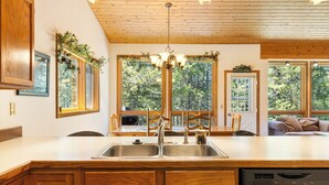 Una cocina con armarios de madera, un lavamanos doble y un lavavajillas.