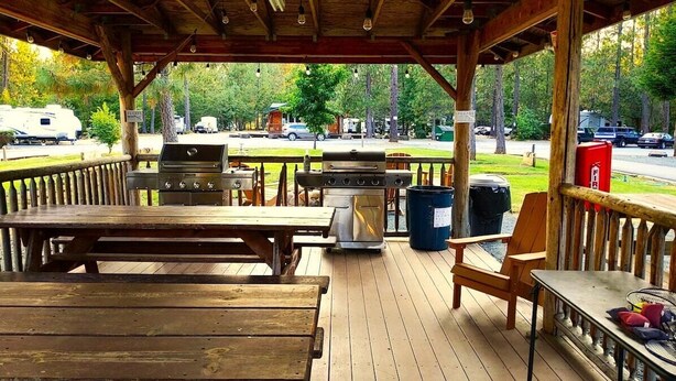 A covered outdoor area with a grill, picnic table, and seating. - Wild Horses Luxury Tipi -  Restrooms and Showers are only a short walk away. (O'Brien)
