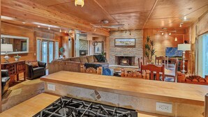 A spacious living area with a fireplace, wooden ceiling, and a stone accent wall. - King (Flagstaff)