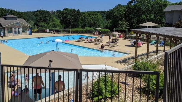 A swimming pool with multiple lanes, sun loungers, and a covered seating area. - "Relaxing Retreat"  7 Night Discount~No Stairs~Indoor Pool~Golf~Trout~Pickleball (Branson)