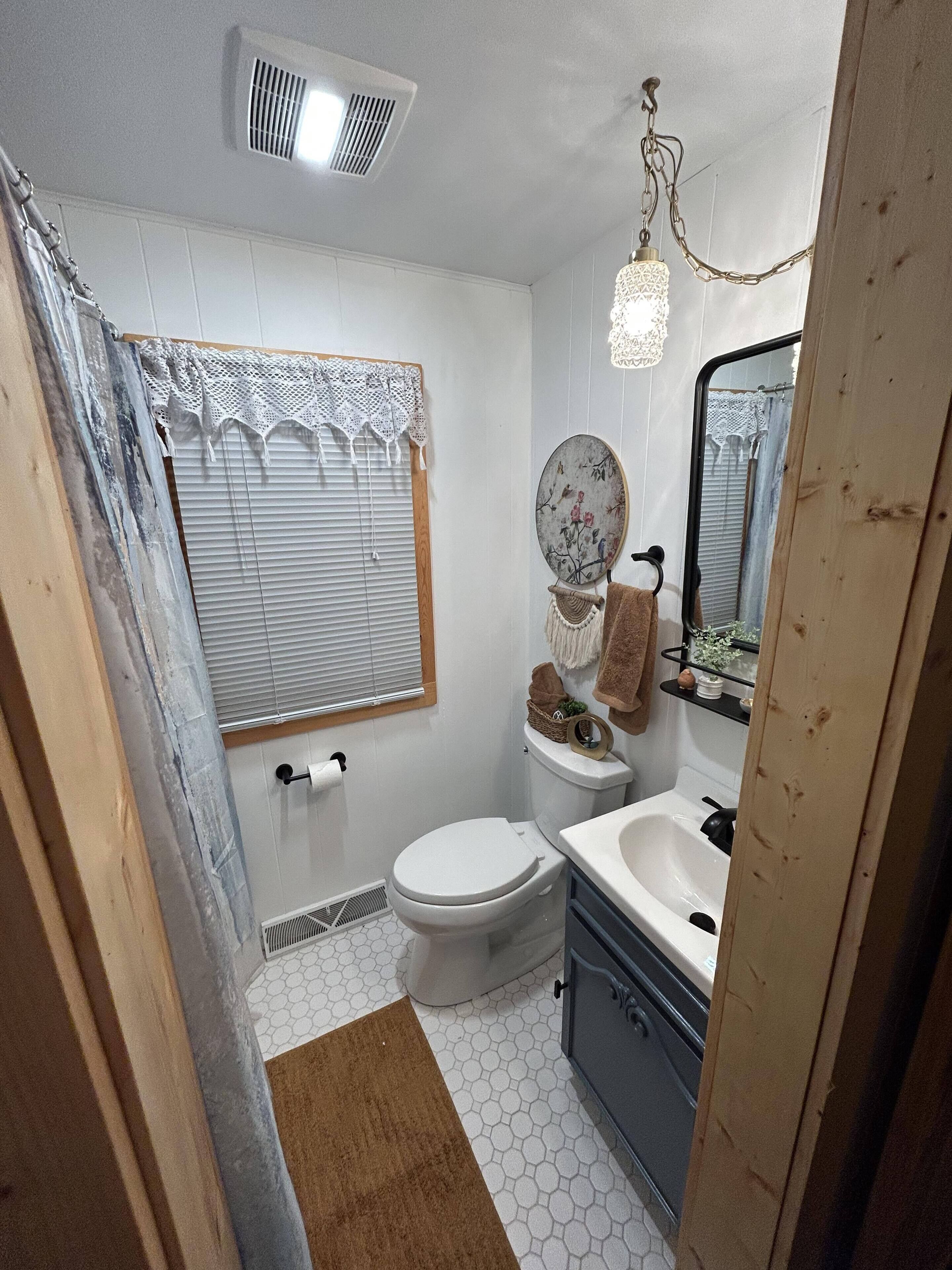 Une petite salle de bain comprenant des toilettes, un lavabo et un miroir.