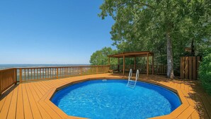 A wooden deck with a swimming pool, a wooden pergola, and a view of the ocean. - Private Pool, Mountain Top Views & Home Theater (Hot Springs)