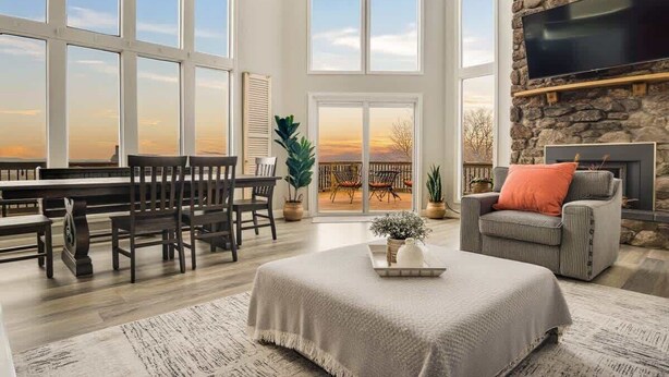 A spacious living room with a large window, a fireplace, and a dining area. - Private Pool, Mountain Top Views & Home Theater (Hot Springs)