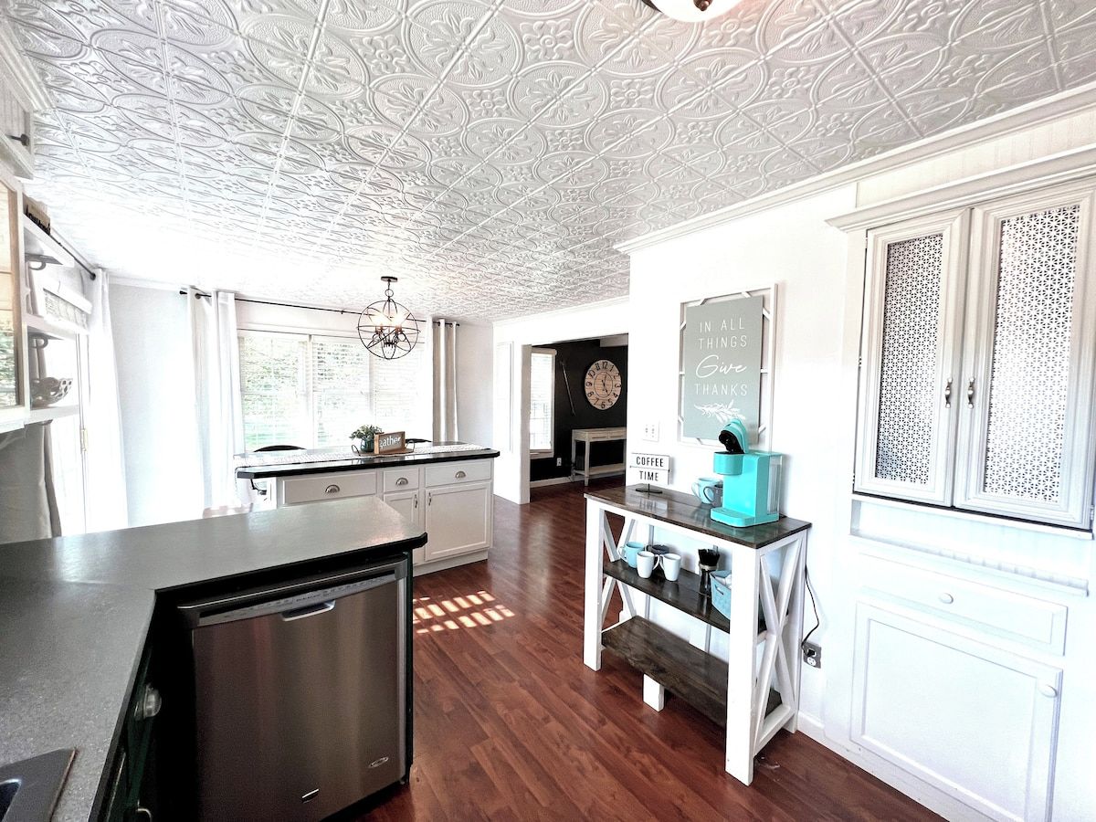 A kitchen with a central island, white cabinetry, and a decorative ceiling.