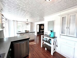 A kitchen with a central island, white cabinetry, and a decorative ceiling. - Whole house in Norfolk, next to White Water Rapids (Norfolk)