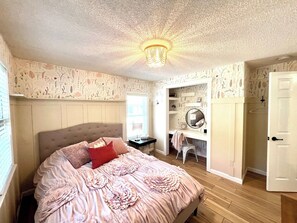 Second bedroom on main floor with queen bed. Closet has been converted to a desk area.