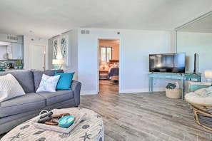 A living room with a sofa, a television, and a dining area with a table and chairs.