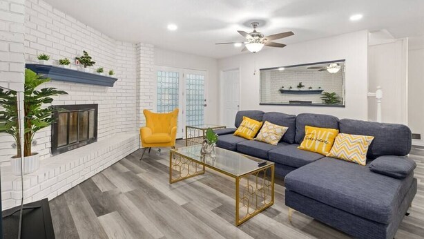 A modern living room with a fireplace, a sofa set, and a ceiling fan. - Stylish 5BR 3BA Home w/Pool Perfect for 16ppl (Allen)