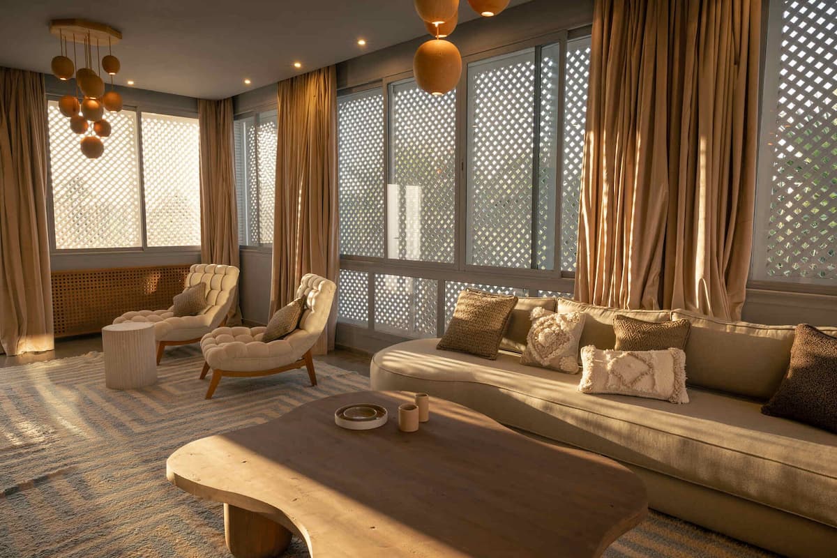 Een moderne woonkamer met een bank, fauteuils en een salontafel.
