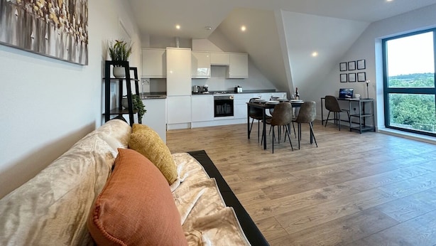 A modern living room with a sofa, a dining area, and a kitchen. - Stylish & Spacious Apartment (Tunbridge Wells)