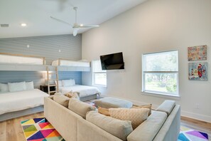 A modern, well-lit bedroom with a bunk bed, a sofa, a TV, and artwork on the walls. - Relax Fireside! Waterfront Malakoff Home w/ Pool (Malakoff)