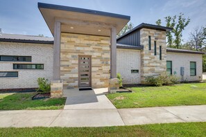 A modern building with a stone facade, a covered entrance, and a small garden area. - Relax Fireside! Waterfront Malakoff Home w/ Pool (Malakoff)
