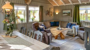 Ein gemütliches Wohnzimmer mit Holzbalkendecke, einer Couch, einem Couchtisch und einem Kamin.