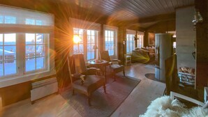 Un cuarto acogedor con ventanas amplias, una chimenea y vistas al exterior.