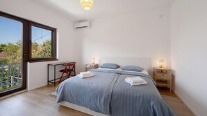 A bedroom with a large bed, a desk, a chair, and a balcony with a view. - Lovely apartment in Brodarica with WiFi (Brodarica)