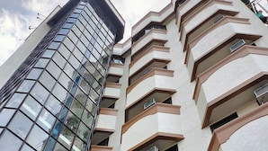 A high-rise building with a modern glass facade and multiple balconies. - Fuente Pension House (Cebu)